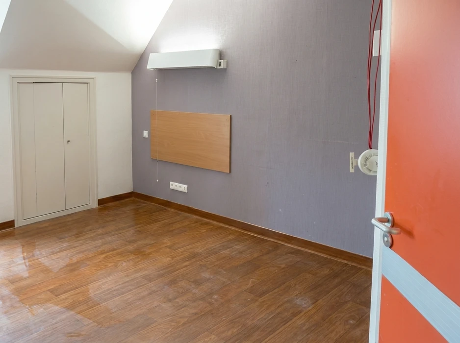 Chambre vide sous combles avec plancher en parquet stratifié ton noyer