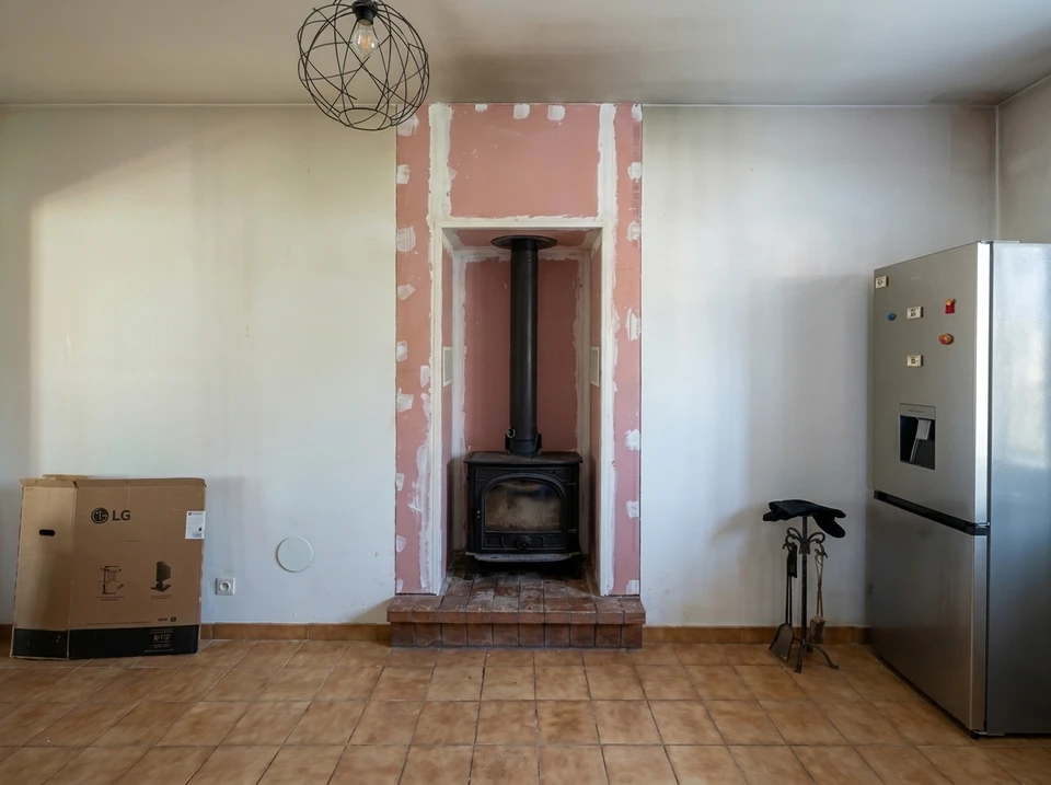 Électricien professionnel en chemise à carreaux travaillant sur installation électrique résidentielle, manipulant fils et connexions dans boîtier mural blanc