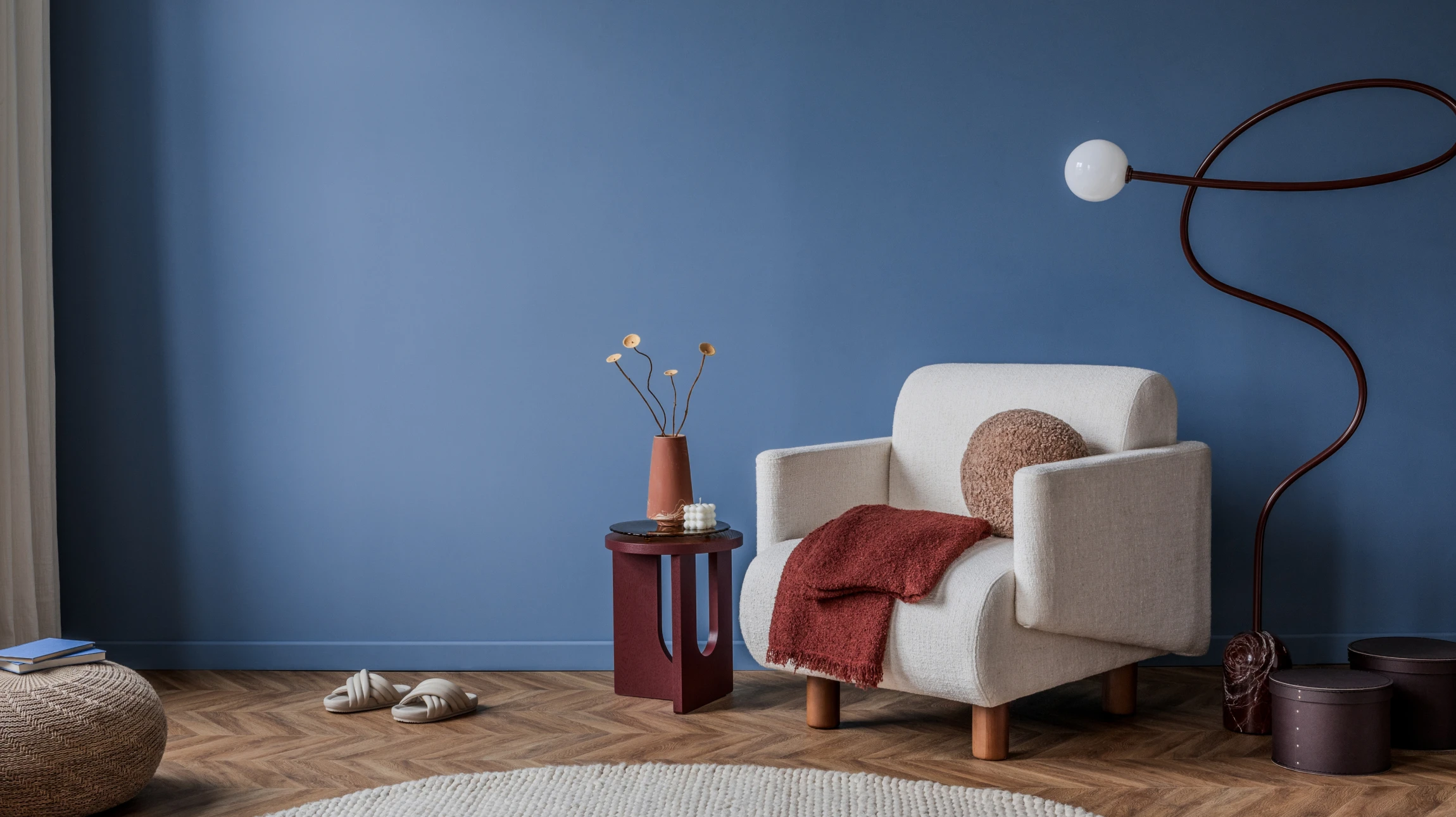 Peintre professionnel en combinaison bleue et casquette blanche applique de la peinture blanche au rouleau sur un mur intérieur